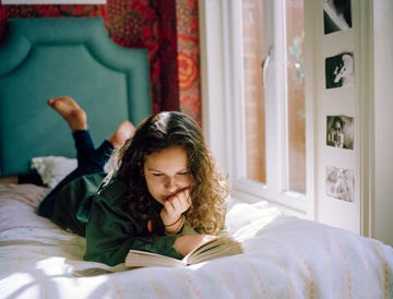 adolescente leyendo tumbada en su cama