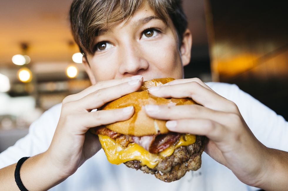 teenager eating a burger