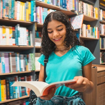 Teenager girl reading book in library teenager girl reading book in library