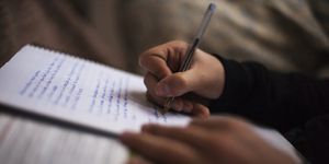Teenager hands writing in a notebook.  He is doing the tasks of the institute.  Spain