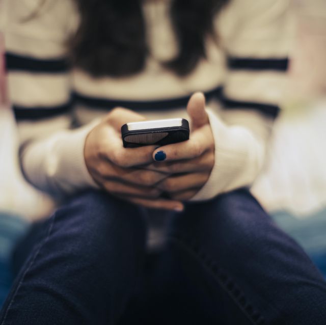 teenager using social media on phone in bedroom