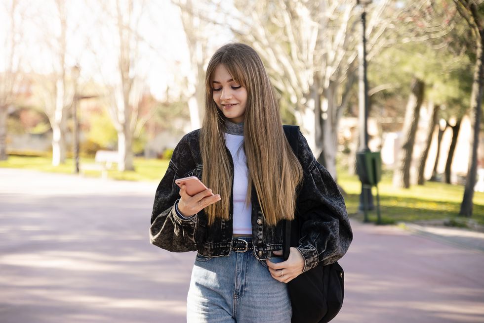 teenager student girl using smartphone outdoors