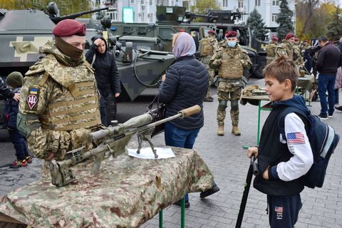 teenager views the sniper rifle during the weapon exhibition