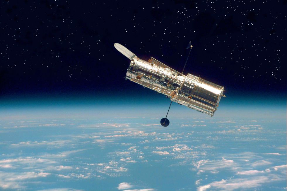 ebbmn5 the hubble space telescope hovers at the boundary of earth and space in this picture, taken after hubbles second servicing