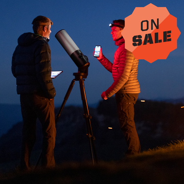 two men looking at telescope at night with on sale badge