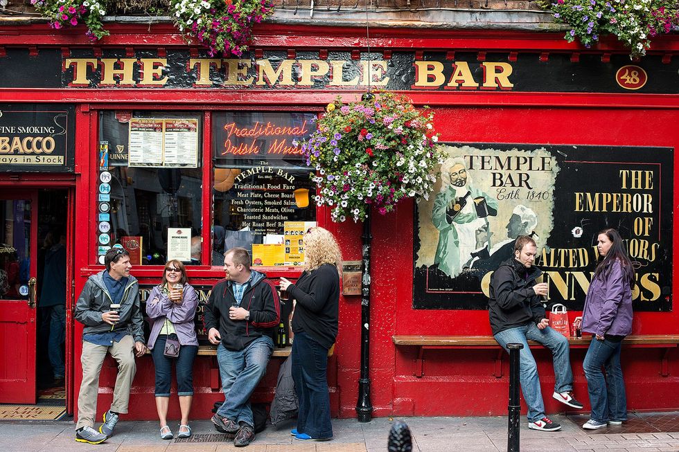 Gasten staan op straat voor het caf The Temple Bar waaraan de hele wijk zijn naam dankt