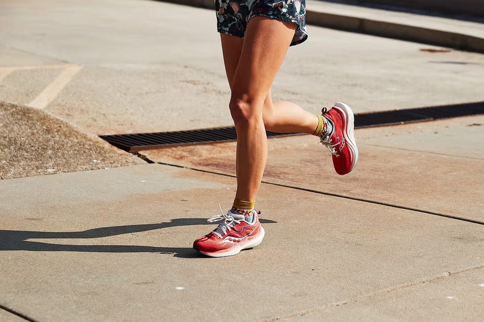 person running on a sidewalk wearing bright red athletic shoes