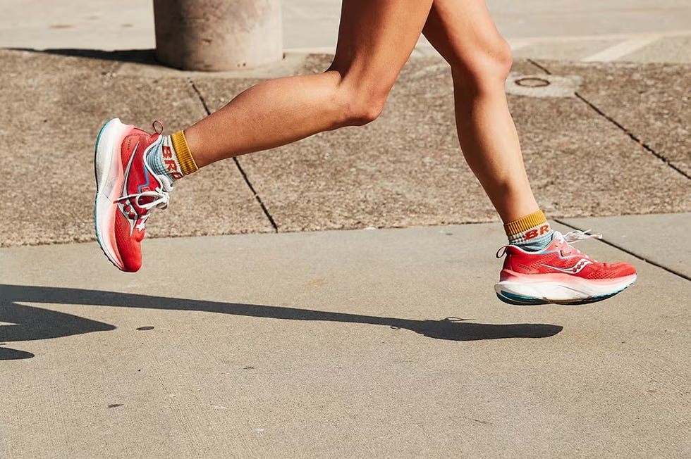 a person running down a pavement in red shoes