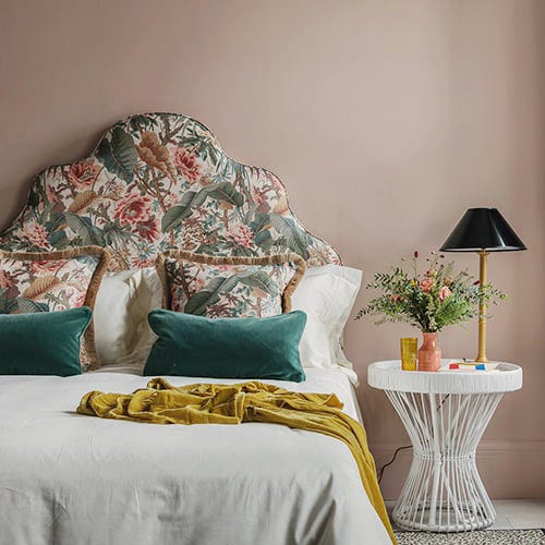 dormitorio con cabecero de tela de flores y mesilla moderna