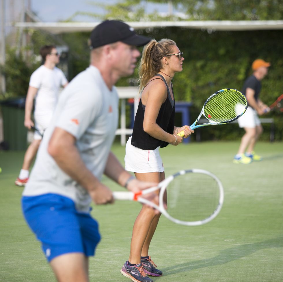 a couple of people holding tennis rackets at neilson messini beachclub