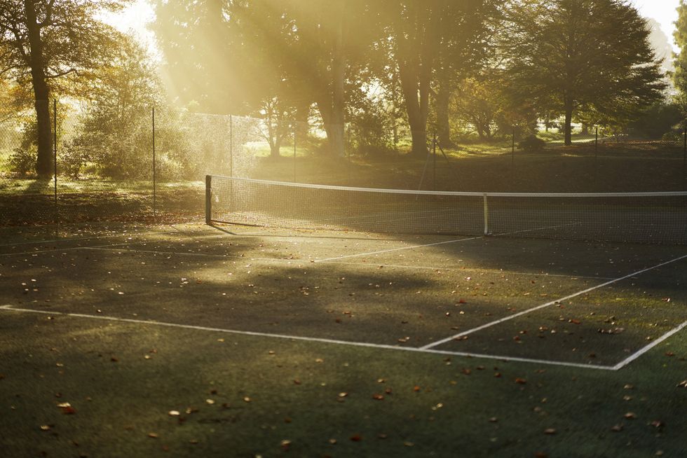 tennis court in autumn with sun beams and mist