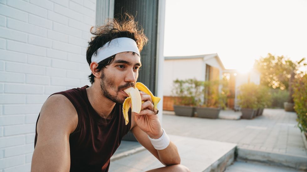 a tennis player is eating a banana during a break