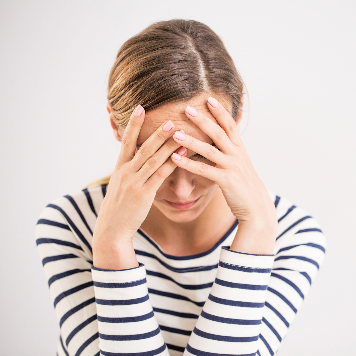 woman holding her head due to tension headache
