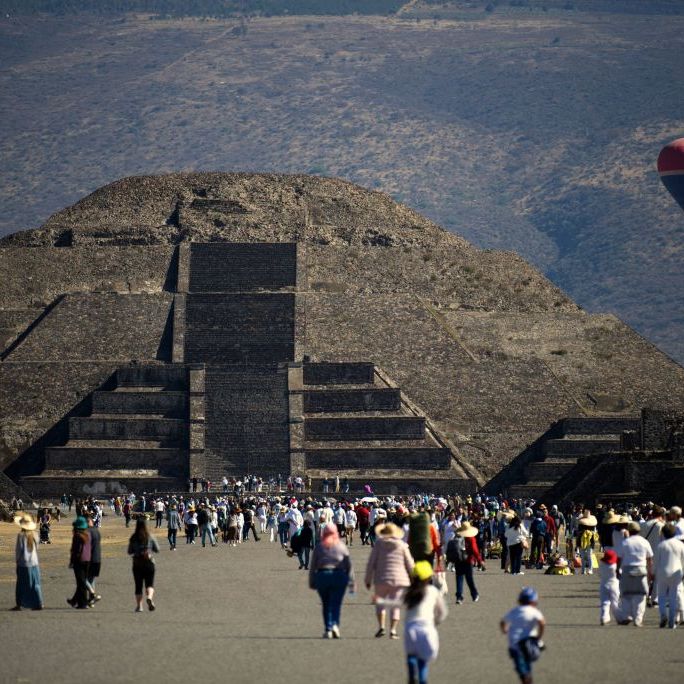 people walk in front of the pyramid of the moon in teotihuacan, mexico state, during the spring equinox celebration on march 20, 2023 photo by claudio cruz  afp photo by claudio cruzafp via getty images