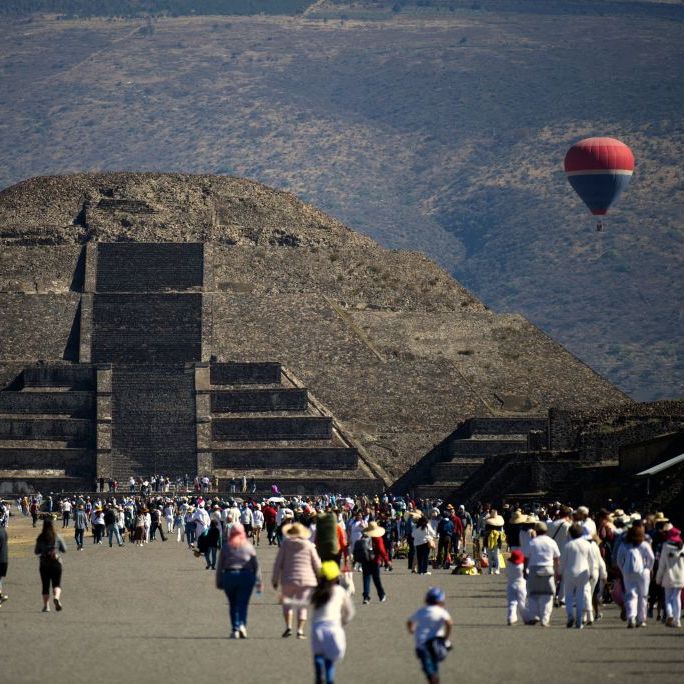 people walk in front of the pyramid of the moon in teotihuacan, mexico state, during the spring equinox celebration on march 20, 2023 photo by claudio cruz  afp photo by claudio cruzafp via getty images