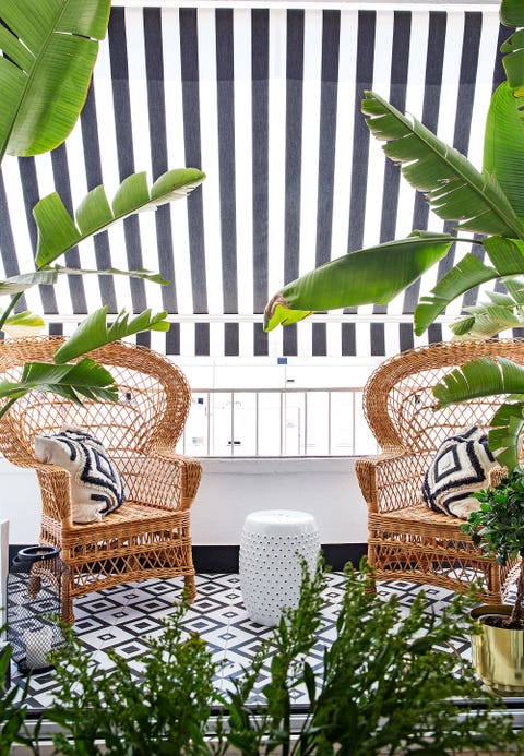 una terraza decorada en blanco y negro con sillones de mimbre