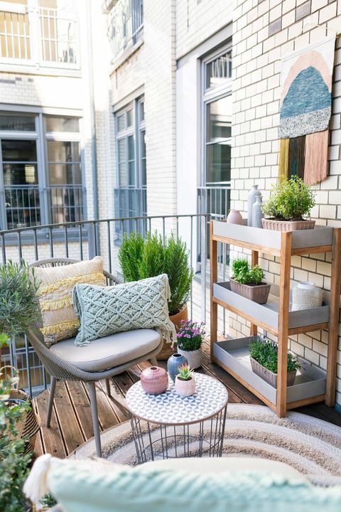 terraza pequeña con butaca y estantería con plantas