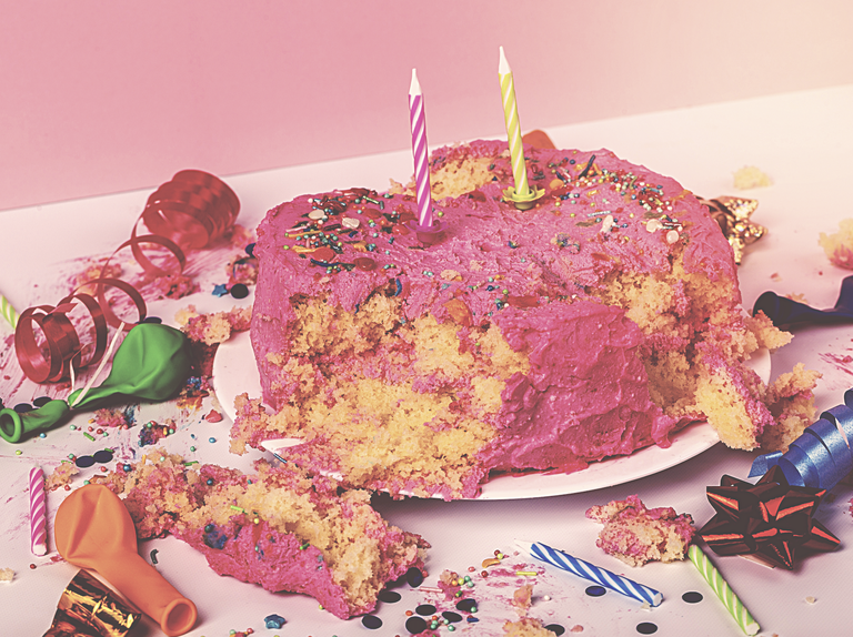 ruined birthday cake with party debris