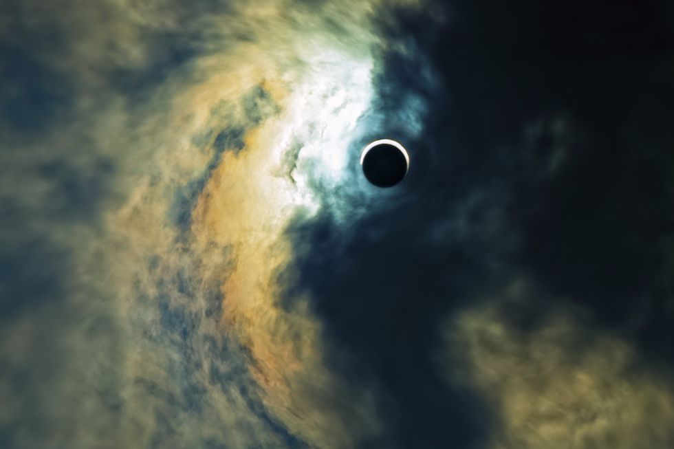 terrifying ominous sky with solar eclipse in the middle dark clouds attack light