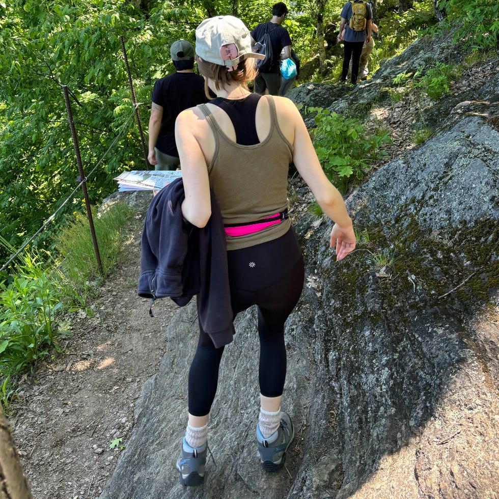 Good Housekeeping test of running belts a woman wearing a pink running belt on a hike