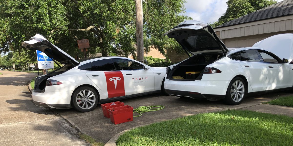 Tesla repair technician car in driveway doing repair