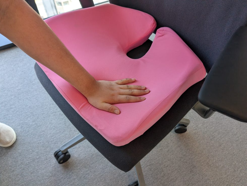 testing the softness of a seat cushion on an office chair