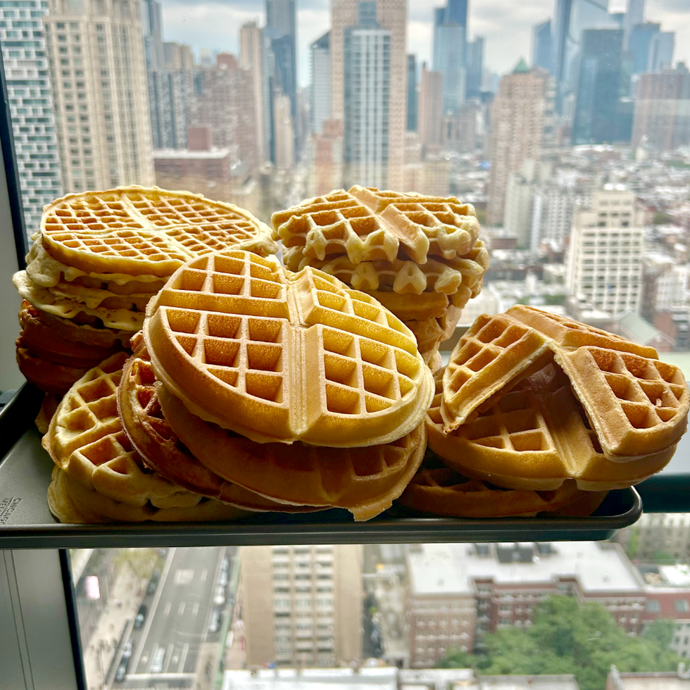 several stacks of waffles on a tray in front of a city skyline