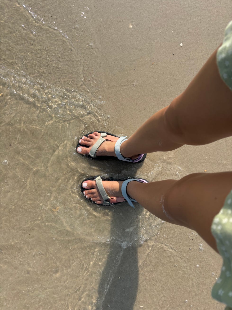 feet wearing the hurricane xlt2 sandal in the ocean