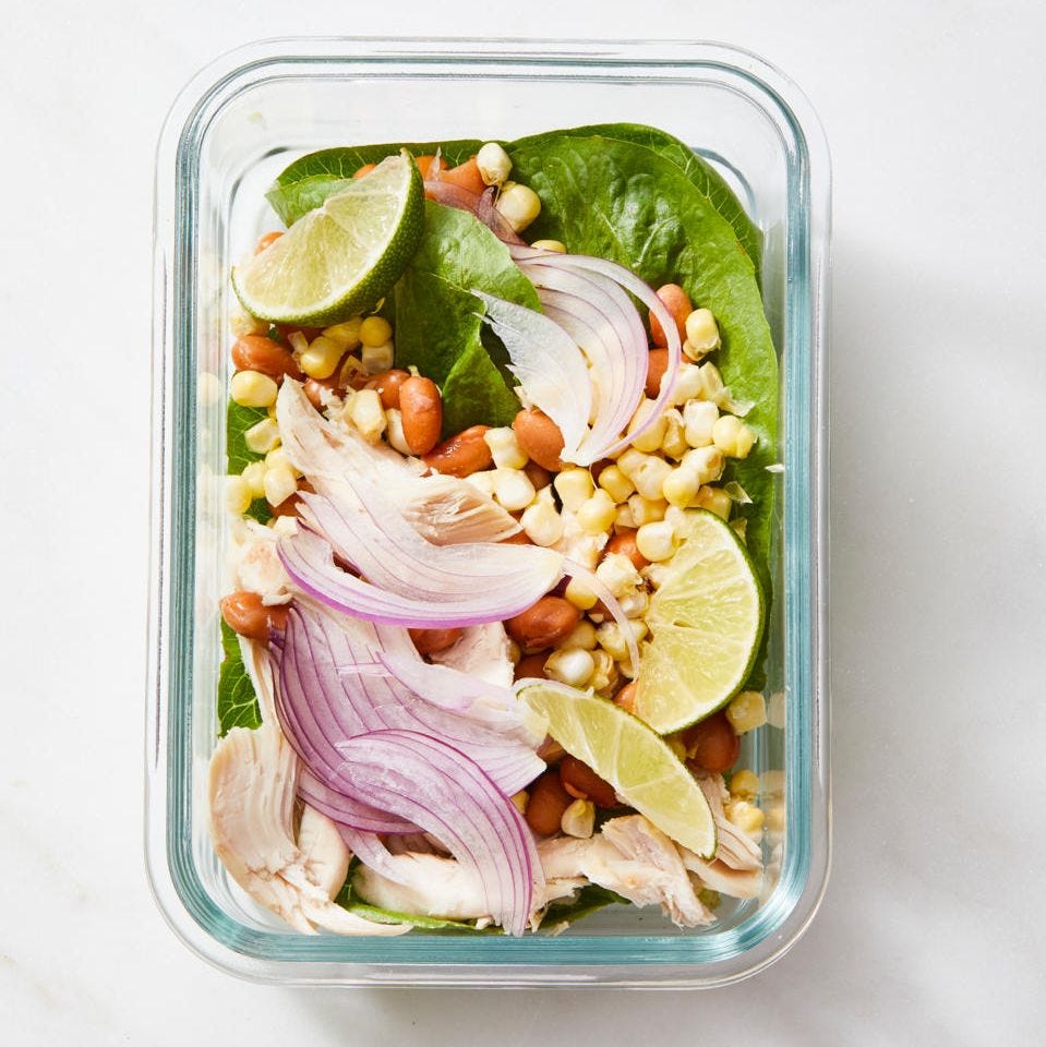 tex mex chicken spring salad with corn and red onion in a glass container