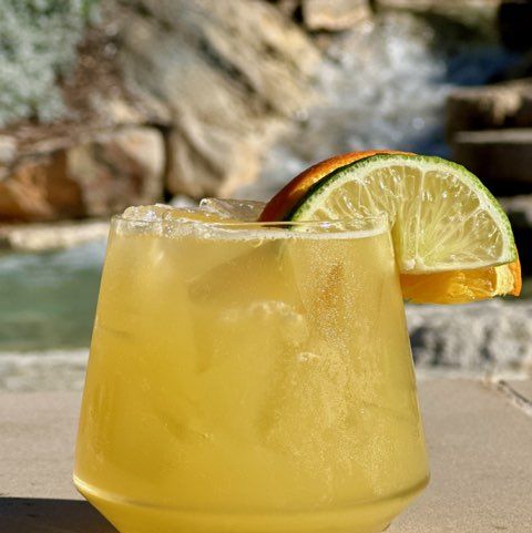 a glass of lemonade with a slice of lemon on top
