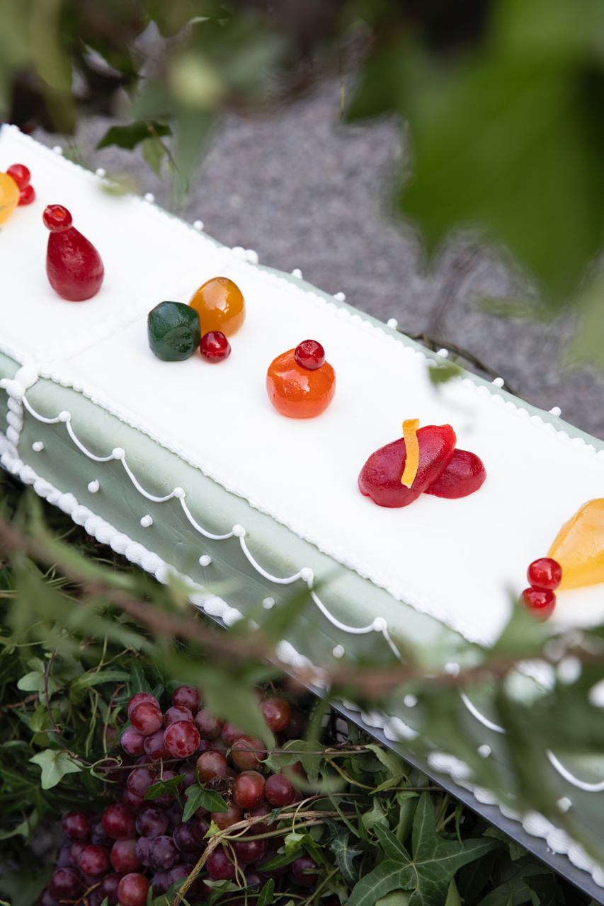 a white frosted cake with red berries and a white frosting