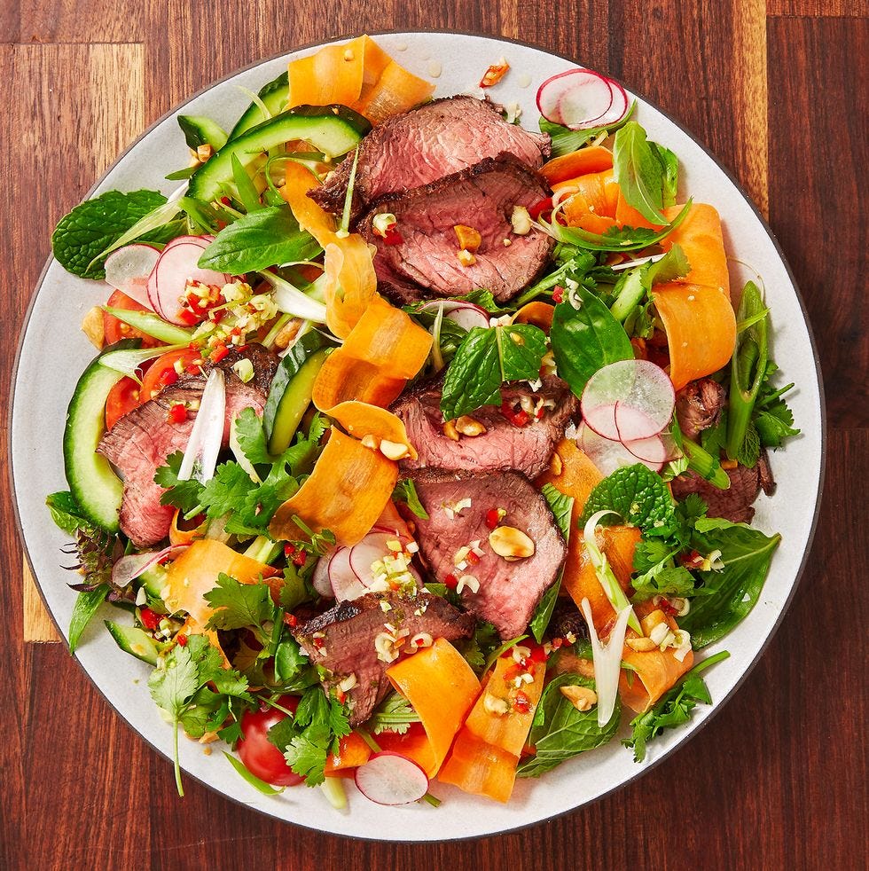 colorful salad with carrots, steak and cilantro on a plate