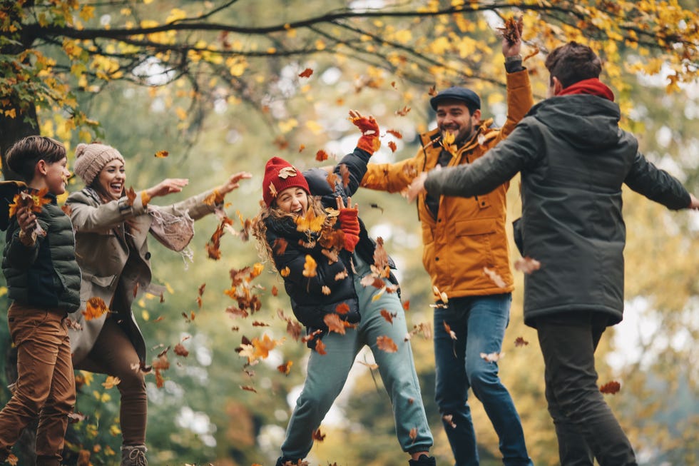 family playing in leaves