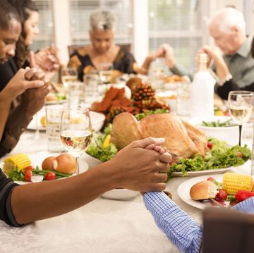 family prays at thanksgiving table holding hands