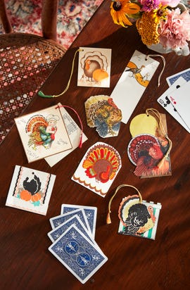 decorative turkey themed tags and playing cards on a wooden table