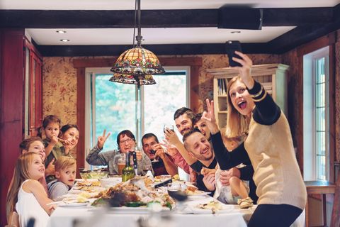 thanksgiving family dinner with woman taking instagram photo