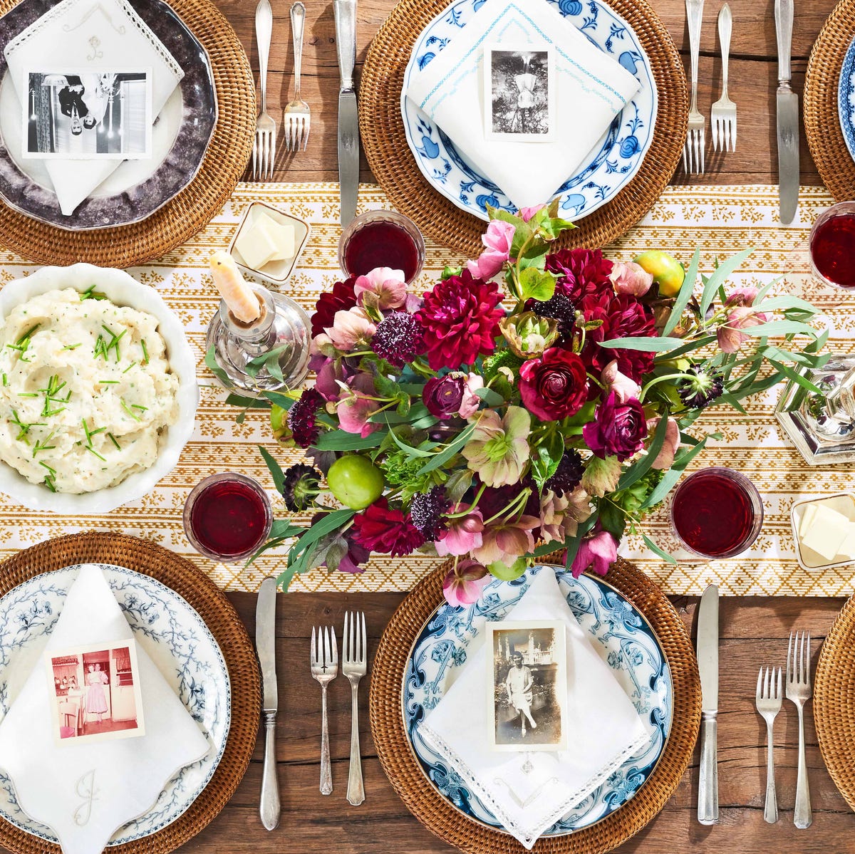 thanksgiving centerpieces with deep purply red flowers, old family photos placed on napkins as place cards