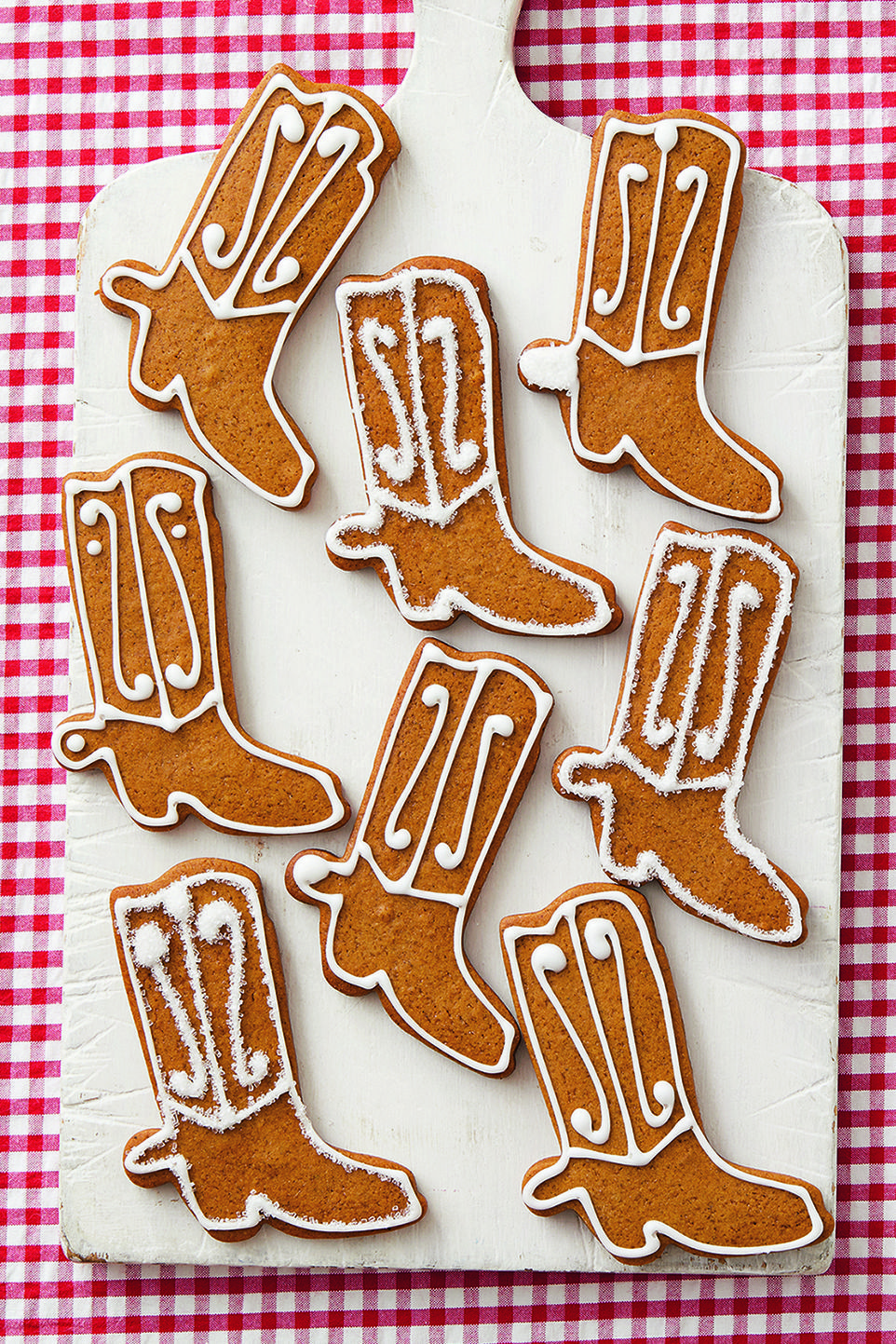 gingerbread cowboy boot cookies on white board