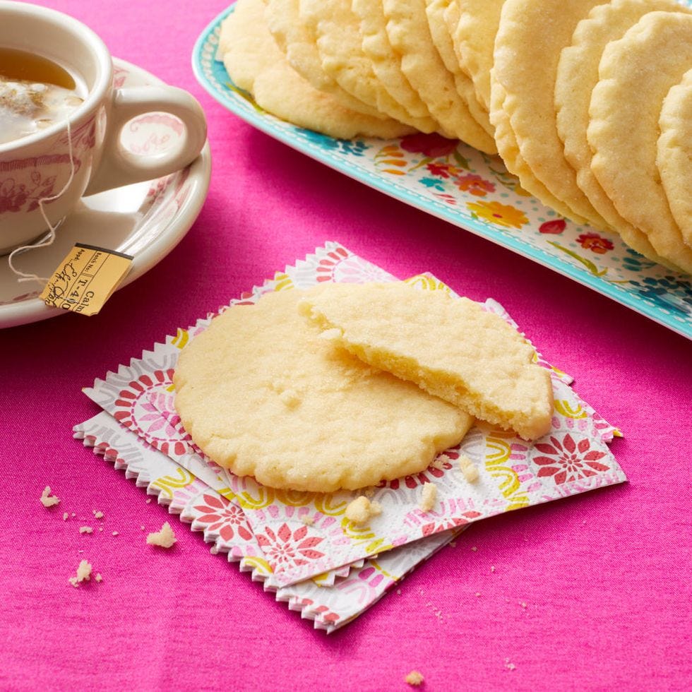 rees sugar cookies on pink surface with tea cup