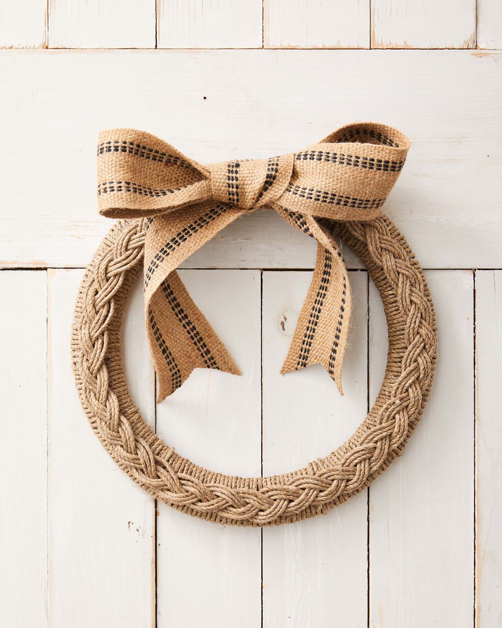 wreath form wrapped in rope topped with a braid made from rope with a bow made from upholstry jute webbing