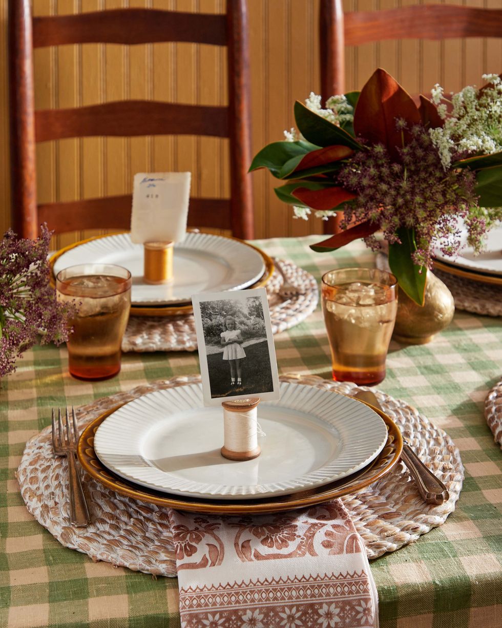 vintage photos inserted into a slit that has been cut into one end of a spool set on a placesetting