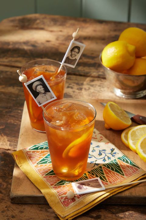 copies of vintage photos attached to drink stirrers sitting in glasses of ice tea