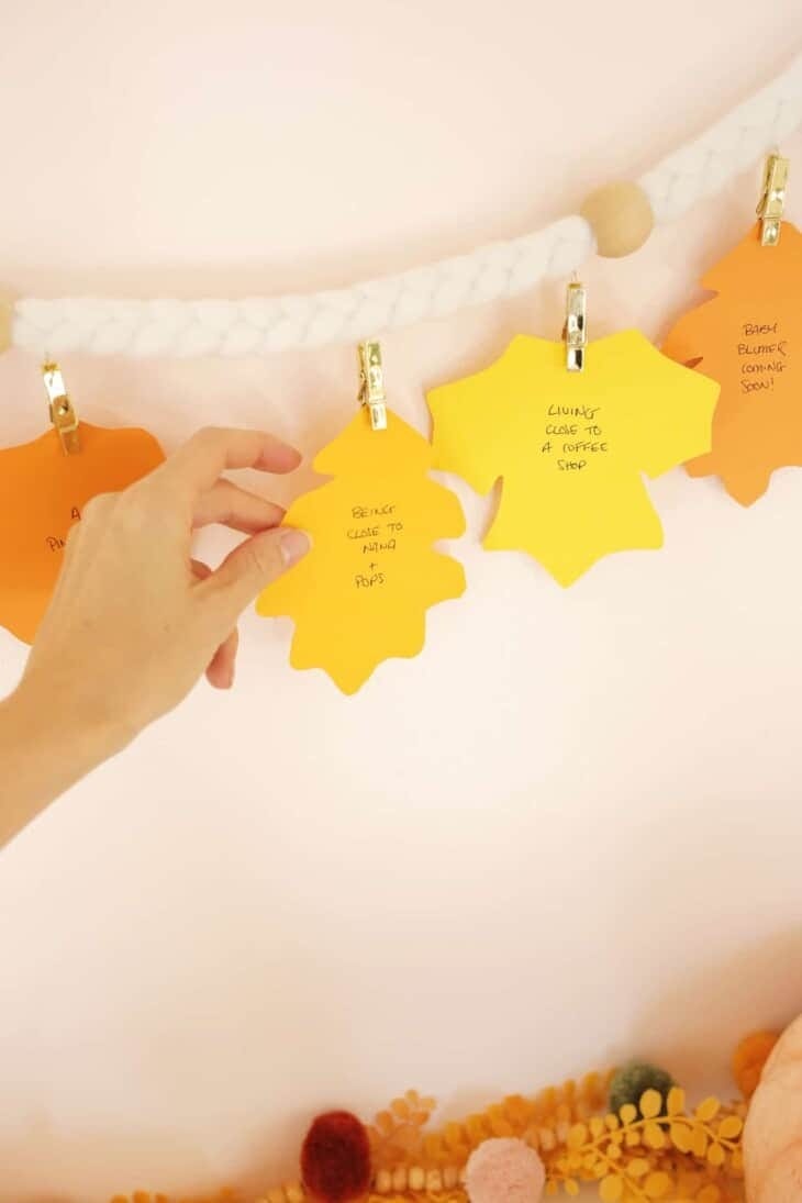 thanksgiving crafts, garland with paper leaves attached and words written on the front of each one