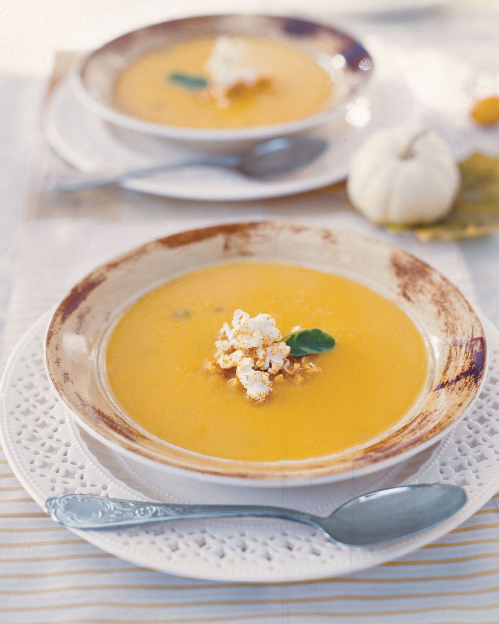 a bowl of butternut squash soup with a spoon