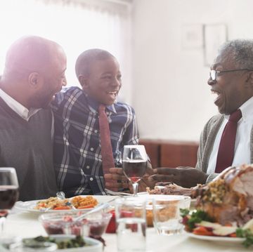grandfather son and grandchild laughing at thanksgiving dinner