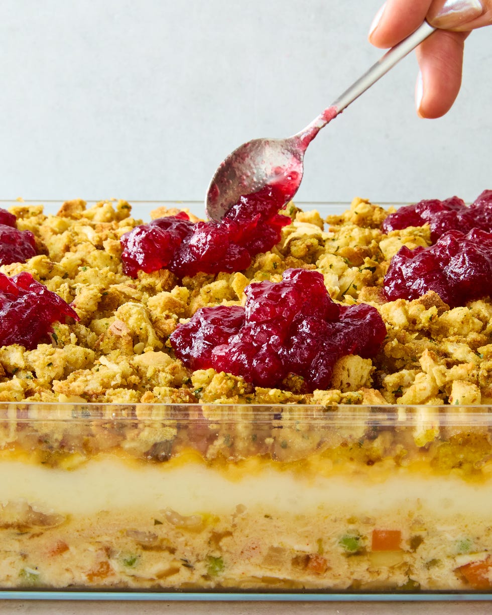 casserole dish layered with mashed potatoes, stuffing, and dolloped with cranberry sauce