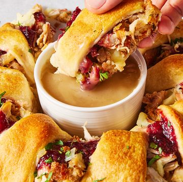a ring of crescent dough surrounding traditional thanksgiving leftover ingredients like cranberry sauce and stuffing