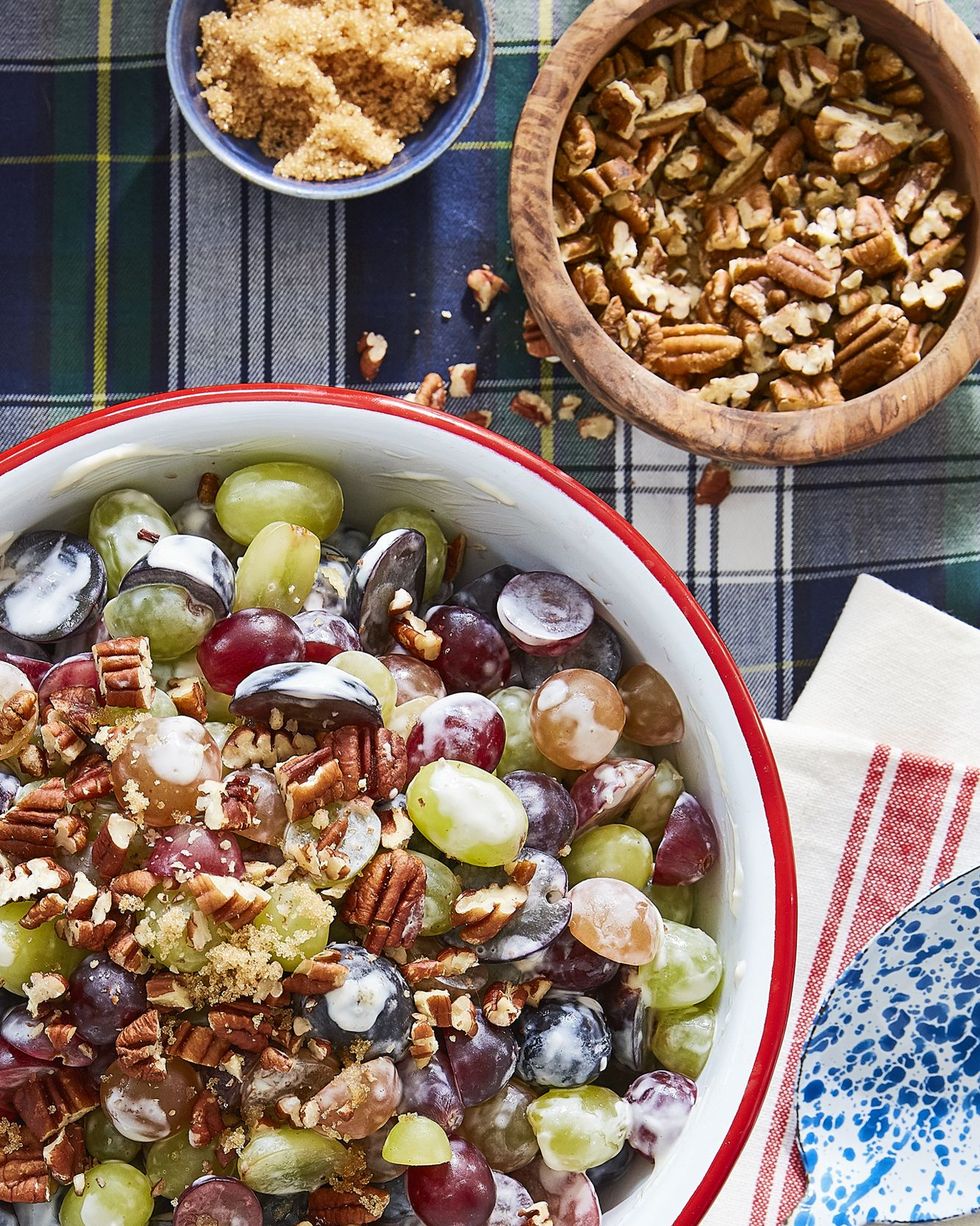 grape salad  in a bowl with pecans and brown sugar in smaller bowls near by