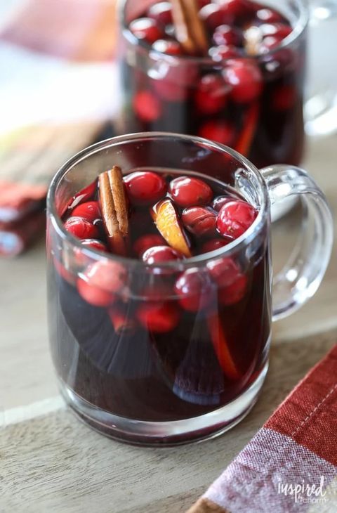 slow cooker thanksgiving sangria with cranberries in glass mug