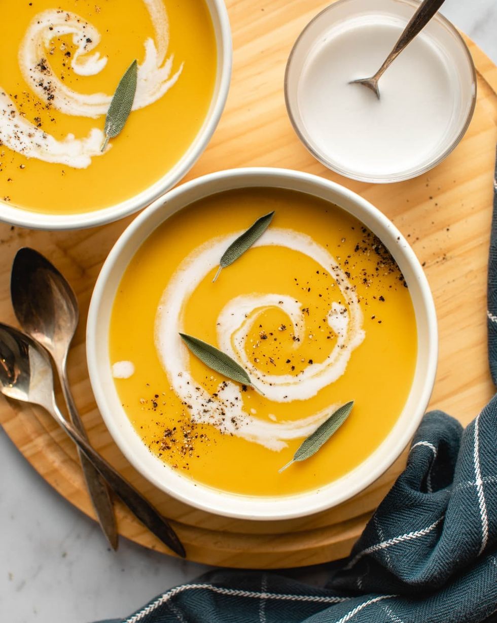 butternut squash apple soup with cream in swirl and fresh sage